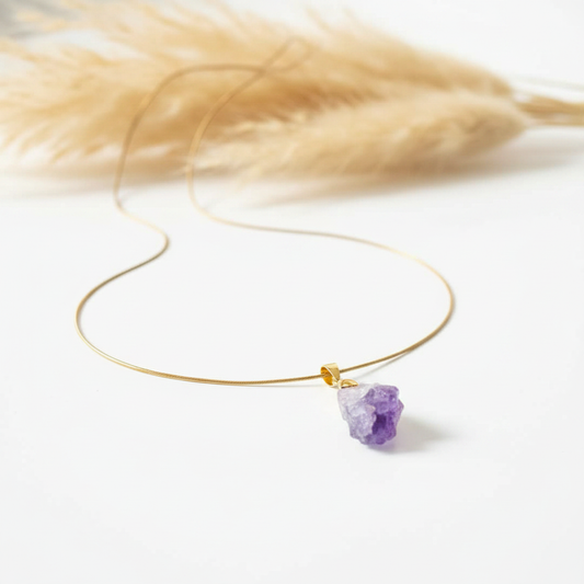 Collier en cordon doré, pendentif d’améthyste brute violette et fermoir discret