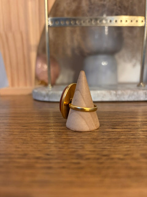 Bague dorée réglable avec agate rouge ovale, vue de côté sur monture