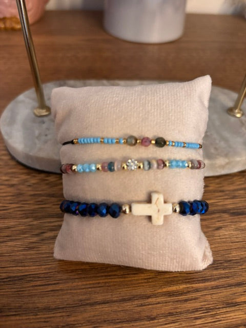 Lot de 3 bracelets perles bleues, dont une croix dorée sur cordon élastique