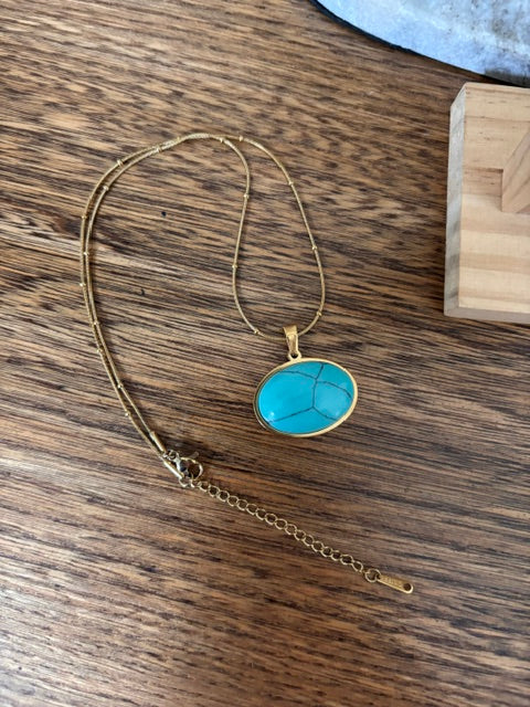 Collier turquoise avec pendentif ovale et chaîne dorée fine, fermoir visible