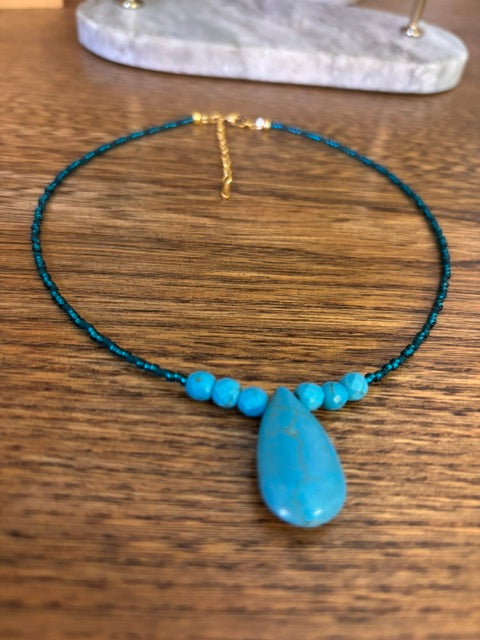 Collier turquoise avec perles et grand pendentif goutte, chaîne dorée fine.