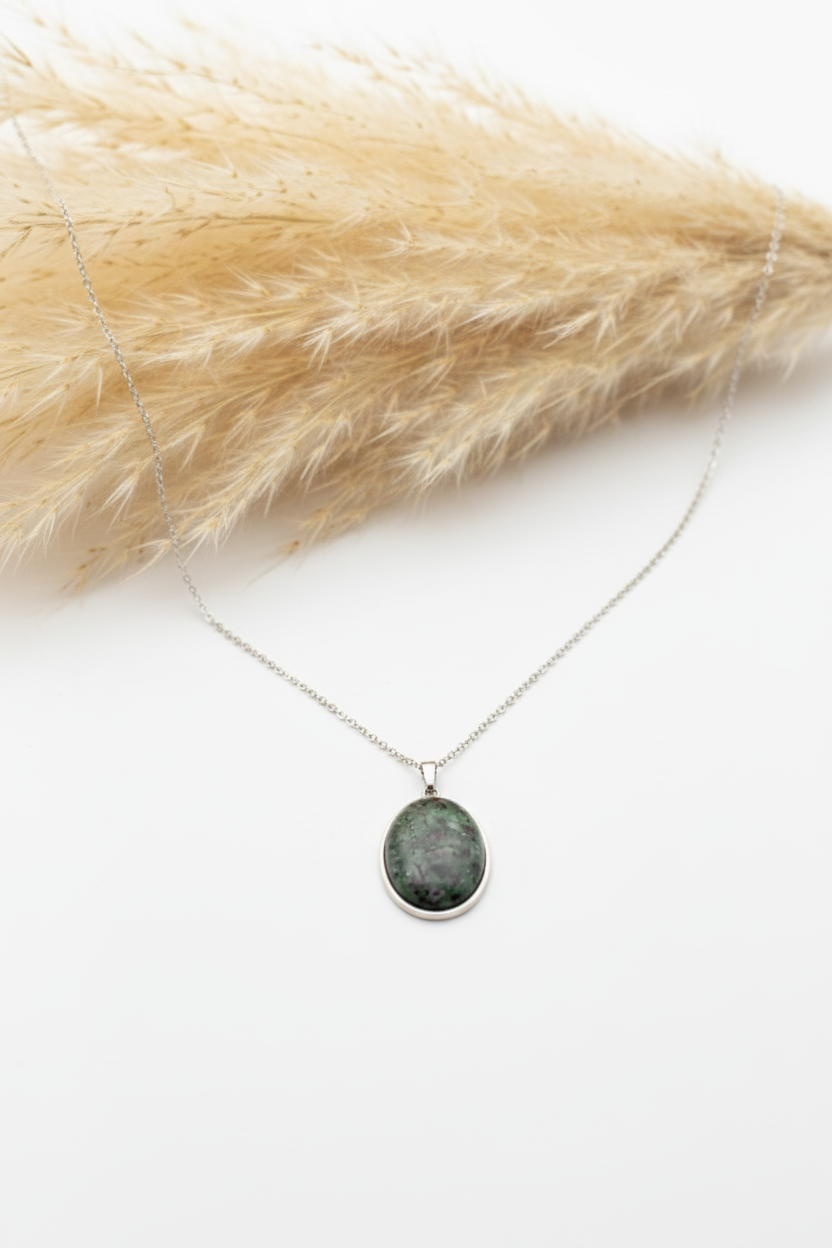 Collier Zoïsite naturelle rose et verte sur fond blanc avec pampas séchée floue, pendentif ovale argenté 18 x 25 mm et chaîne 316L de 44 cm