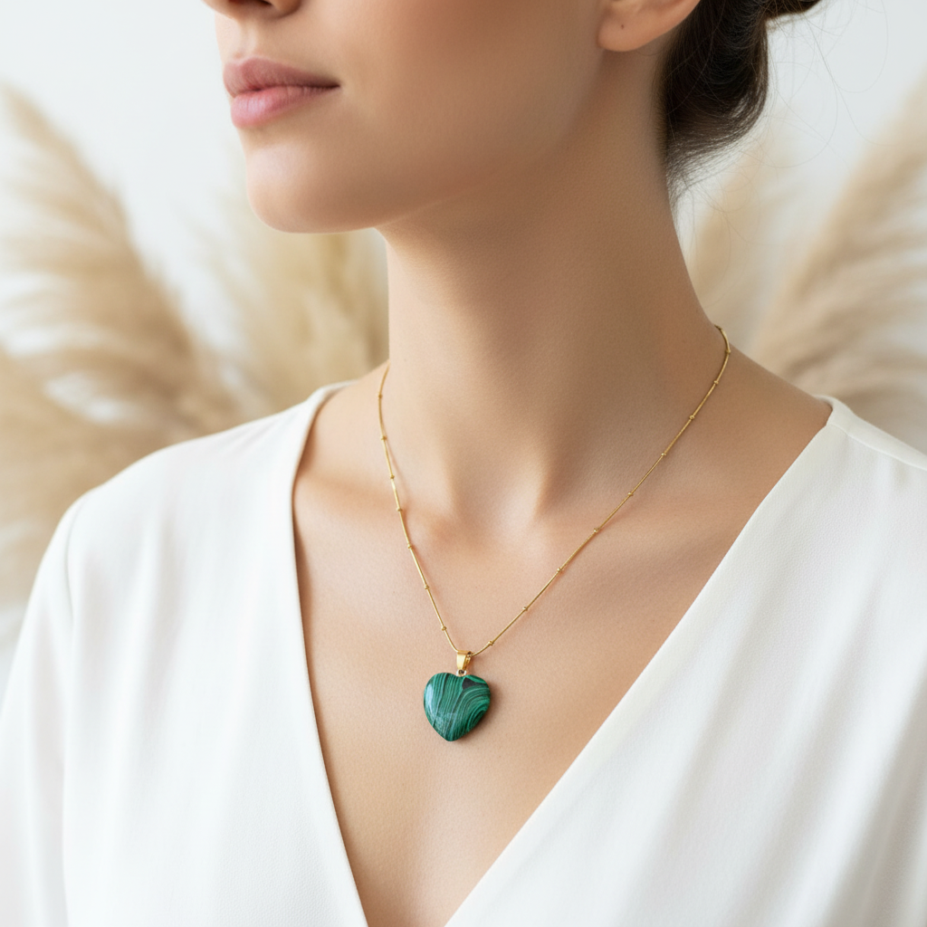 Collier à pendentif cœur malachite vert sur chaîne dorée, porté au cou.