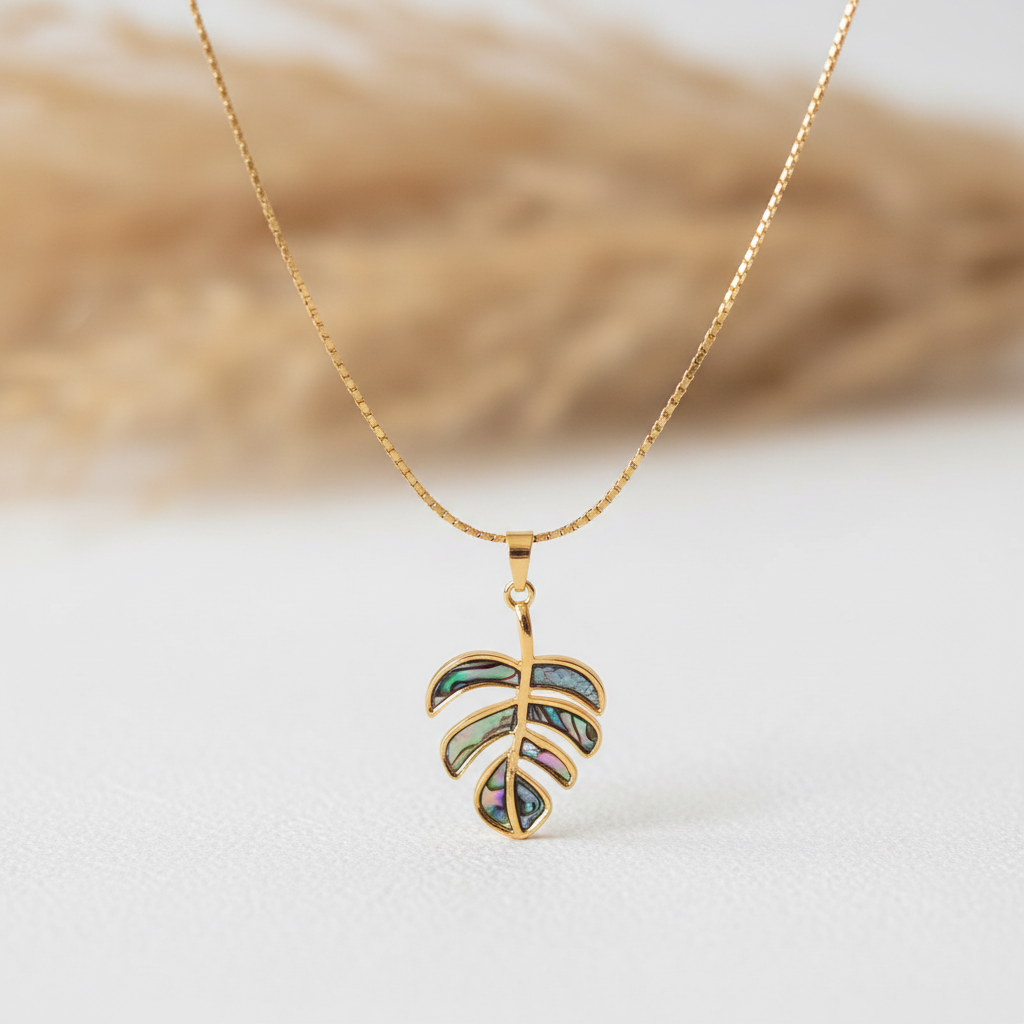 Collier chaîne dorée et pendentif feuille de monstera avec détails nacrés multicolores