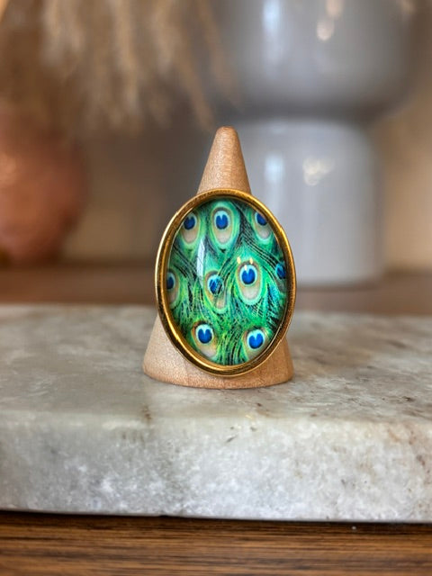 Bague réglable dorée en acier inox, cabochon ovale plume de paon vert-bleu, vue de face
