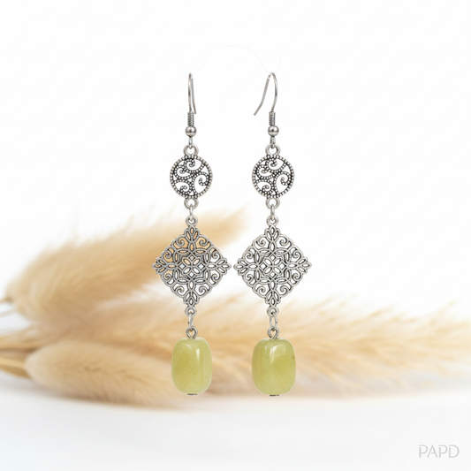 Paire de boucles d’oreilles pendantes argentées, motifs floraux et pierres vertes.