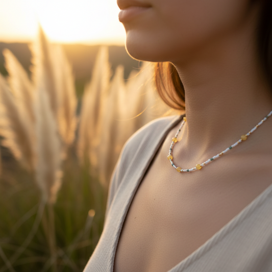Collier de perles bleu clair et jaunes, porté au cou, fermoir doré