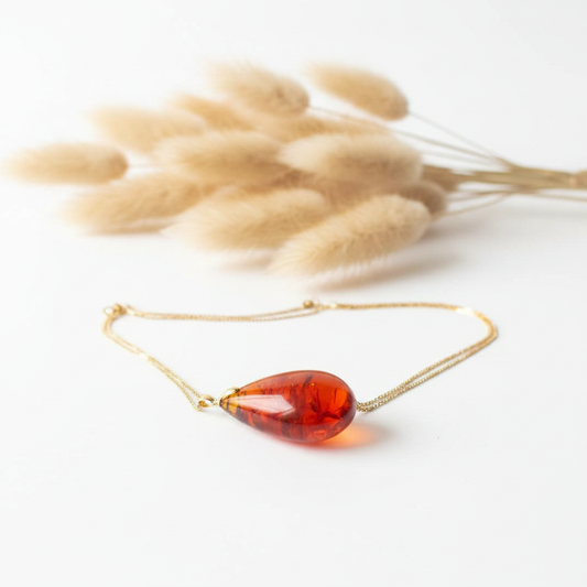 Collier à pendentif goutte en ambre rouge sur chaîne fine dorée