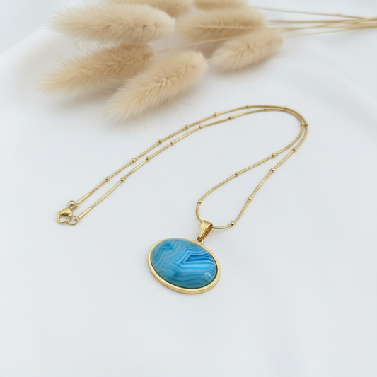 Collier fin doré avec pendentif cabochon pierre bleue et chaîne perles.