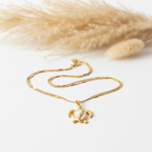 Collier chaîne fine dorée avec pendentif tortue nacré.