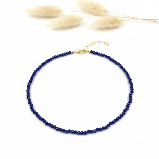 Collier de perles facettées bleues avec fermoir doré, style bohème élégant.