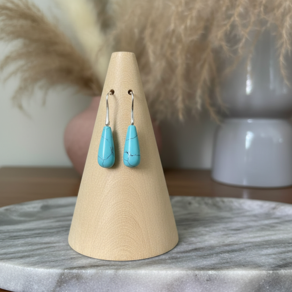 Dormeuses argentées pierre turquoise naturelle forme larme sur présentoir bois clair et marbre gris, style boho-chic, fait main France