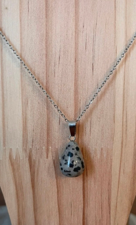 Pendentif goutte en pierre dalmatienne sur chaîne à maillons argentés.