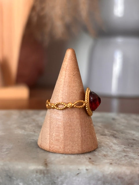 Bague dorée ajustable : cabochon grenat ovale, monture ronde en relief vintage.