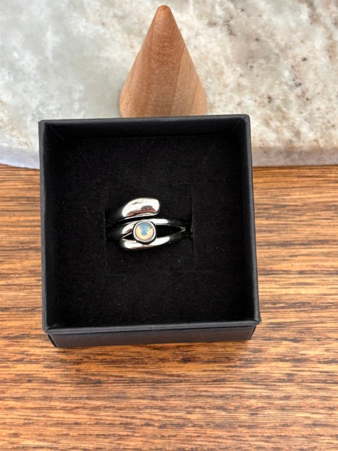Bague ajustable en argent inox avec opale blanche ronde, dans écrin noir
