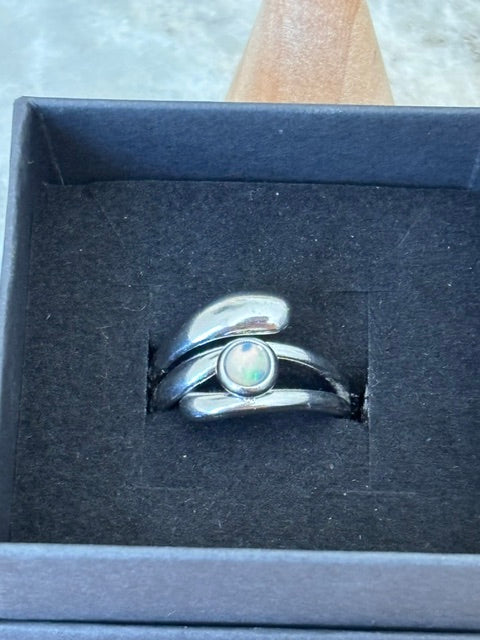 Gros plan sur bague ajustable argent inox: opale blanche ronde
