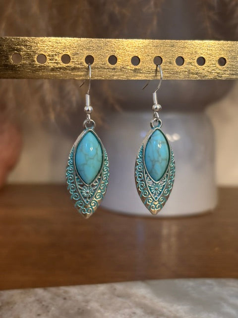Boucles d’oreilles pendantes argentées à breloque turquoise, motifs ajourés en goutte.