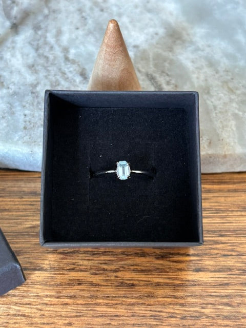 Bague argent 925 rhodié avec topaze bleue taillée rectangulaire, en écrin noir.