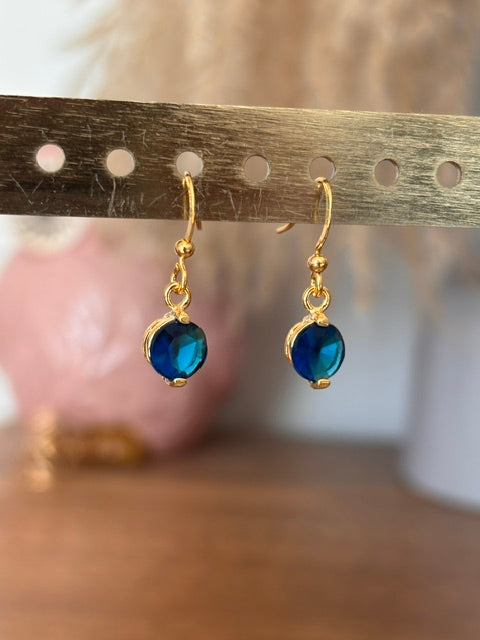 Boucles d’oreilles dormeuses plaquées or avec pampille sertie de saphir bleu.