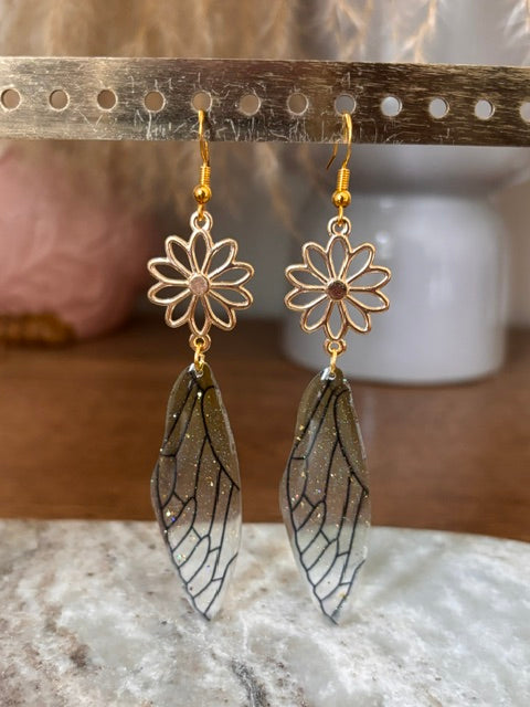 Boucles dormeuses fleur, ailes pendantes foncées pailletées, finitions dorées