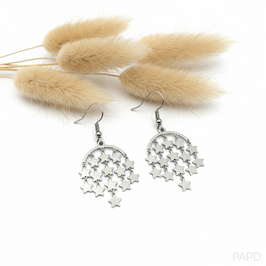 Boucles d’oreilles argentées pendantes, grands pendentifs en forme d’étoiles ajourées.