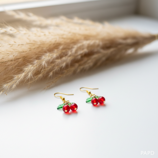 Boucles d’oreilles pendantes avec deux cerises rouges et monture dorée