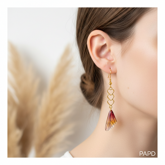 Boucles d’oreilles pendantes à cœurs dorés et ailes façon fée rouge/jaune pailletées