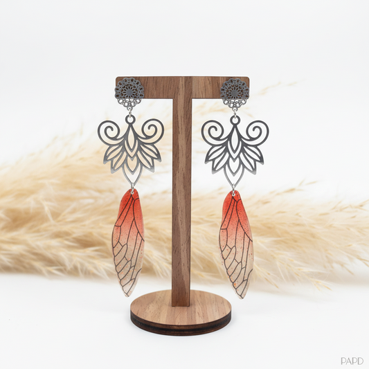 Boucles d’oreilles bohèmes : acier inox, aile filigranée et pampilles rouges.