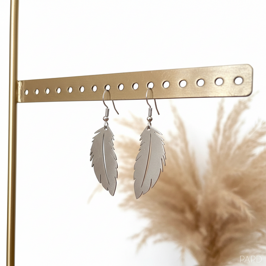 Boucles d’oreilles pendantes en forme de plumes argentées, détail filigrané