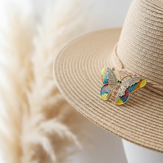 Broche papillon dorée multicolore à strass, sur chapeau en paille