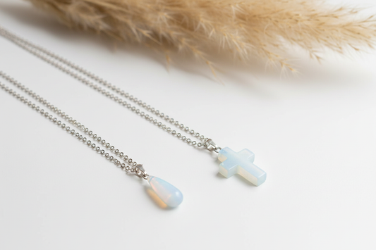 Colliers argentés jumelés : pendentifs croix et goutte opaline bleu clair
