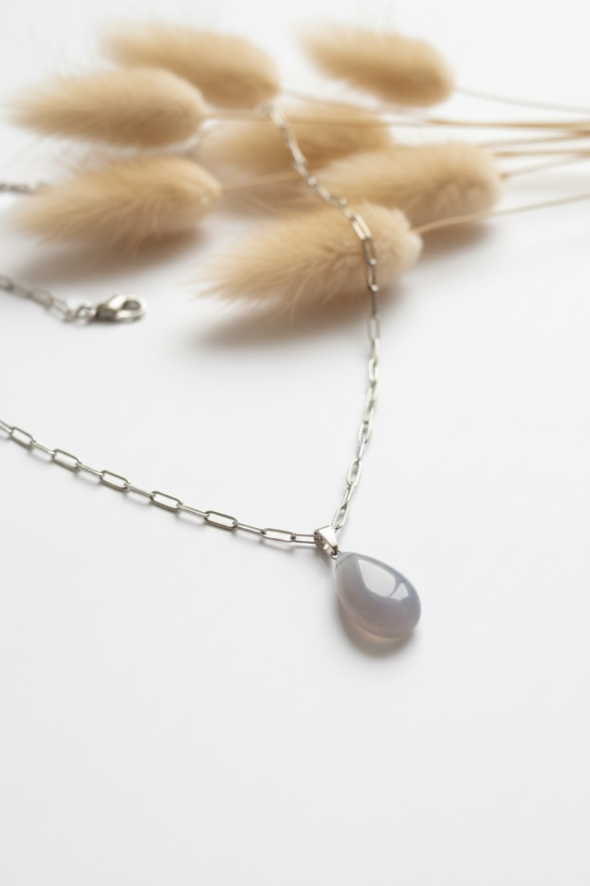 Collier avec pendentif goutte en pierre de Lune naturelle grise et gris perle, chaîne gourmette argentée en acier inoxydable, longueur 45 cm avec 5 cm d’extension, sur fond blanc avec pampas