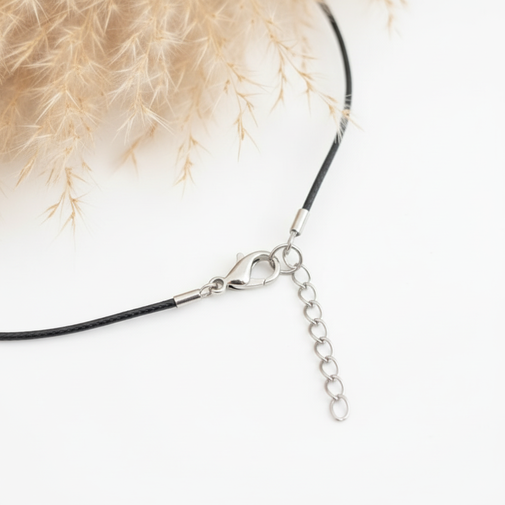 Gros plan du cordon de collier en simili cuir noir avec fermoir mousqueton et chaînette de rallonge de 5 cm
