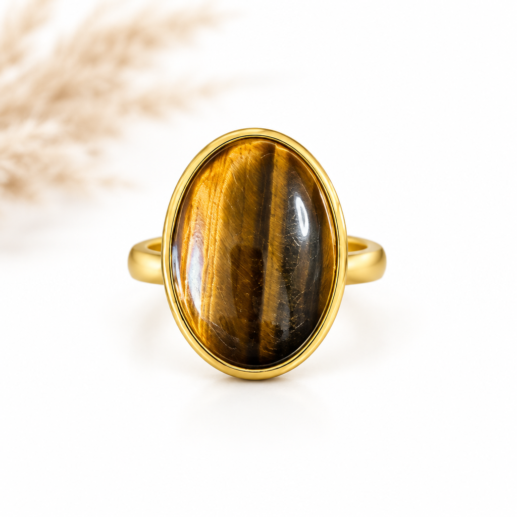 Bague dorée ajustable avec cabochon ovale d’Œil de Tigre brun et miel sur fond blanc