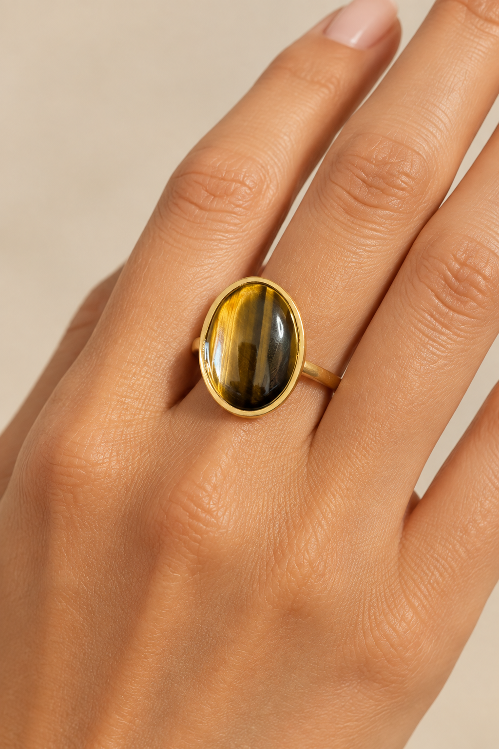 Bague dorée ajustable en Œil de Tigre brun et miel portée au doigt