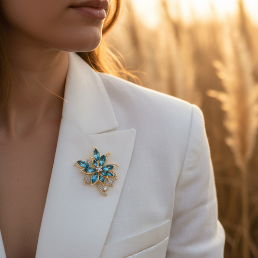 Broche fleur dorée et bleu sur veste blanche, bijou fantaisie étincelant